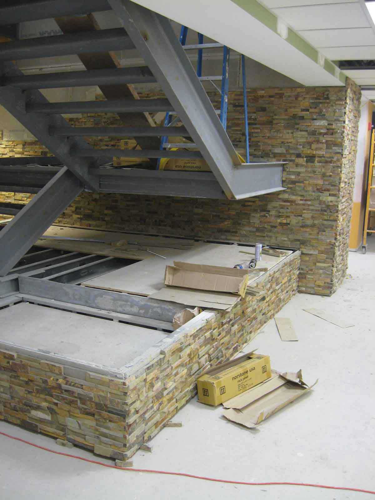 Progress Installation Shot of Norstone Ochre Rock Panels being installed on stairwell at healtchare facility in town of Boston Massachusetts